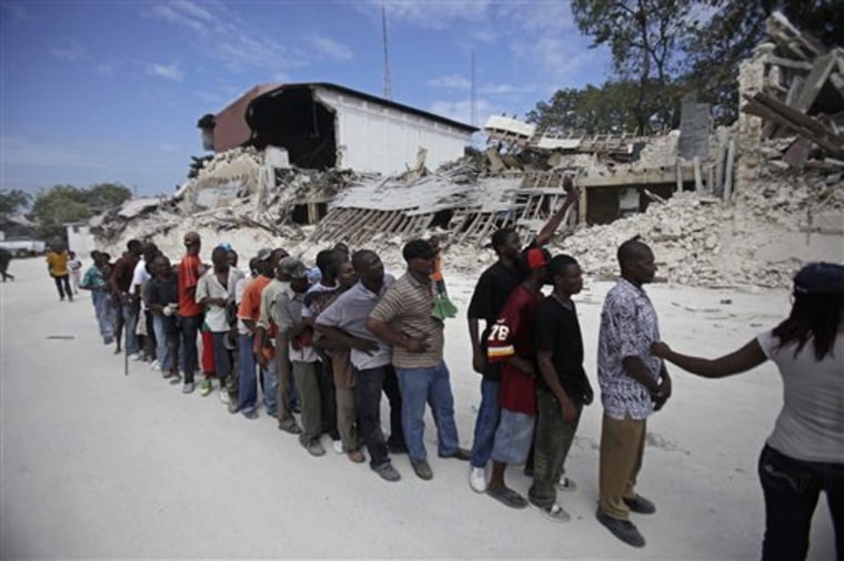 People wait in line for food rations in earthquake-torn Port-au-Prince, Tuesday, Jan. 26, 2010.  A 7.0-magnitude earthquake hit Haiti on Jan. 12, killing and injuring thousands and leaving many homeless.  (AP Photo/Ariana Cubillos)